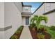 Inviting front entrance with a well-maintained walkway and lush tropical landscaping around the entryway at 8815 Windlass Cv, Parrish, FL 34219