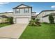 Charming two-story home with light grey siding, well-manicured lawn, and an attached two-car garage at 8815 Windlass Cv, Parrish, FL 34219
