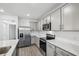 Modern kitchen features gray cabinets, stainless appliances, and white countertops and backsplash at 8815 Windlass Cv, Parrish, FL 34219