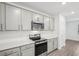 Modern kitchen features gray cabinets, stainless appliances, white countertops, and backsplash at 8815 Windlass Cv, Parrish, FL 34219