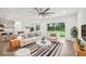 Stylishly staged living room features modern furnishings, wood-look floors, and a seamless open layout at 8815 Windlass Cv, Parrish, FL 34219