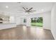 Open concept living room with wood-look floors and kitchen access, ideal for entertaining at 8815 Windlass Cv, Parrish, FL 34219