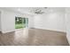 Bright, airy living room with wood-look floors and large sliding glass doors to backyard at 8815 Windlass Cv, Parrish, FL 34219