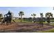 Community playground with lush landscaping, a slide, climbing apparatus, and distant views of neighborhood homes and a pond at 8815 Windlass Cv, Parrish, FL 34219