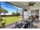 Screened porch overlooking lush green lawn, mature trees, and comfortable patio furniture at 9402 71St E Ave, Palmetto, FL 34221
