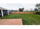 Fenced backyard with a wooden deck and green grass, offering privacy and space for outdoor activities at 9402 71St E Ave, Palmetto, FL 34221