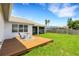 Sprawling backyard featuring a well-manicured lawn, a wooden deck, and a screened in porch at 9402 71St E Ave, Palmetto, FL 34221