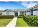 A beautiful home with a well-maintained lawn, blue door, and trimmed bushes at 9402 71St E Ave, Palmetto, FL 34221