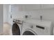 Laundry room featuring a white Samsung washer and dryer, white cabinets, and neutral tile flooring at 9402 71St E Ave, Palmetto, FL 34221