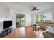 Spacious living room with wood floors, neutral walls, ceiling fan and sliding glass doors to screened lanai at 9402 71St E Ave, Palmetto, FL 34221