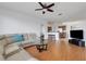 Open-concept living room with view to the kitchen, wood floors, and sliding door access to a screened lanai at 9402 71St E Ave, Palmetto, FL 34221