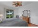 The main bedroom has a ceiling fan, a dresser, and sliding door access to the lanai with a view of the yard at 9402 71St E Ave, Palmetto, FL 34221