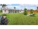Manicured green backyard features lawn, small decorative trees and an enclosed patio at 107 Van Dyck Dr, Nokomis, FL 34275