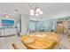 Open floor plan dining area features a chandelier and seamless connection to the living room and a glimpse into the well-equipped kitchen at 107 Van Dyck Dr, Nokomis, FL 34275
