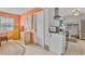 A welcoming entryway featuring warm peach-colored walls, functional furnishings, and a glimpse into the adjacent kitchen at 107 Van Dyck Dr, Nokomis, FL 34275