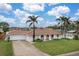 Charming single-story home with a well-manicured lawn, palm trees, and a tile roof at 107 Van Dyck Dr, Nokomis, FL 34275