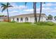 Inviting single-story home boasts arched entryways, a tile roof, palm trees, and lush landscaping at 107 Van Dyck Dr, Nokomis, FL 34275