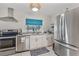 Bright kitchen featuring stainless steel appliances, white cabinetry, granite countertops, and a stylish window shade at 107 Van Dyck Dr, Nokomis, FL 34275