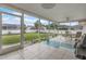 Enclosed back patio features a white tile floor, ceiling fan and views of the green backyard at 107 Van Dyck Dr, Nokomis, FL 34275
