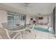 Enclosed back patio features a white tile floor, ceiling fan and seating area at 107 Van Dyck Dr, Nokomis, FL 34275