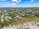 Expansive aerial view of a coastal neighborhood with lush greenery and the ocean in the background at 109 Palmetto Ave, Anna Maria, FL 34216