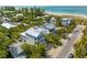 Gorgeous aerial view of a home near the beach, featuring balconies and a lush, tropical landscape at 109 Palmetto Ave, Anna Maria, FL 34216