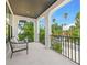 Inviting covered balcony with comfortable seating, perfect for relaxing and enjoying the surrounding views at 109 Palmetto Ave, Anna Maria, FL 34216