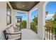 Spacious balcony with seating area and stunning view of the ocean and palm trees at 109 Palmetto Ave, Anna Maria, FL 34216