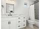 Bright bathroom featuring a white vanity with marble countertop and shower with decorative tile at 109 Palmetto Ave, Anna Maria, FL 34216