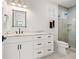 Well-lit bathroom with double sink vanity, modern fixtures, and glass-enclosed shower at 109 Palmetto Ave, Anna Maria, FL 34216