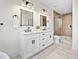 Modern bathroom with double vanity, white cabinets, black hardware, and tiled shower at 109 Palmetto Ave, Anna Maria, FL 34216