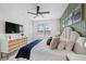 Bedroom with decorative green wall, TV, and plush bedding for ultimate relaxation at 109 Palmetto Ave, Anna Maria, FL 34216