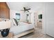 Bright bedroom featuring wood accent wall, ceiling fan, and door to balcony at 109 Palmetto Ave, Anna Maria, FL 34216