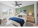 Bright bedroom featuring a modern ceiling fan, large window, and neutral color palette at 109 Palmetto Ave, Anna Maria, FL 34216
