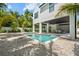 Rear exterior of two story home showcasing the pool, covered patio, and tropical landscaping at 109 Palmetto Ave, Anna Maria, FL 34216