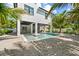 Beautiful back exterior featuring covered patio, a rectangular pool, and tropical landscaping at 109 Palmetto Ave, Anna Maria, FL 34216
