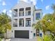Stunning three-story modern home with black framed balconies and a two-car garage at 109 Palmetto Ave, Anna Maria, FL 34216