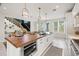 Bright, white kitchen with wood countertops on island, with an oven and seating at 109 Palmetto Ave, Anna Maria, FL 34216