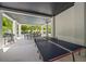 Large covered patio featuring a ping pong table, dining area and outdoor kitchen with tropical foliage at 109 Palmetto Ave, Anna Maria, FL 34216