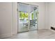 View of covered patio with dining and lounge seating through sliding glass doors from inside home at 109 Palmetto Ave, Anna Maria, FL 34216