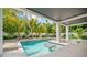 Inviting pool with tanning ledge, tropical landscaping, and covered patio for outdoor entertaining at 109 Palmetto Ave, Anna Maria, FL 34216