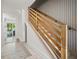Modern staircase with wooden railing, vertical trim accent wall, and light wood flooring at 109 Palmetto Ave, Anna Maria, FL 34216