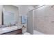 Cozy bathroom featuring a tiled shower with curtain, single sink with dark vanity and light blue towels at 12047 Kingsley Trl, Parrish, FL 34219