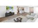 Open-concept living room featuring modern decor, wood floors, and seamless kitchen access at 12064 Lansing Gln, Parrish, FL 34219