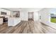 Bright, open-concept living space with wood floors and direct view of kitchen area at 12064 Lansing Gln, Parrish, FL 34219