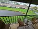 Relaxing screened balcony with seating overlooks green landscaped grounds at 1211 Capri Isles Blvd # 116, Venice, FL 34292