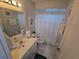 Bright bathroom featuring a single sink vanity, framed mirror, shower, and tile flooring at 1211 Capri Isles Blvd # 116, Venice, FL 34292