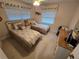Bright bedroom featuring two twin beds, a ceiling fan, and neutral carpeting at 1211 Capri Isles Blvd # 116, Venice, FL 34292