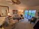 Cozy living room with neutral tones, sliding glass doors to the lanai, and ample seating at 1211 Capri Isles Blvd # 116, Venice, FL 34292