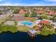 Aerial view showcasing a community pool, tennis courts, and lakefront gazebo at 1227 56Th St W # 1227, Bradenton, FL 34209